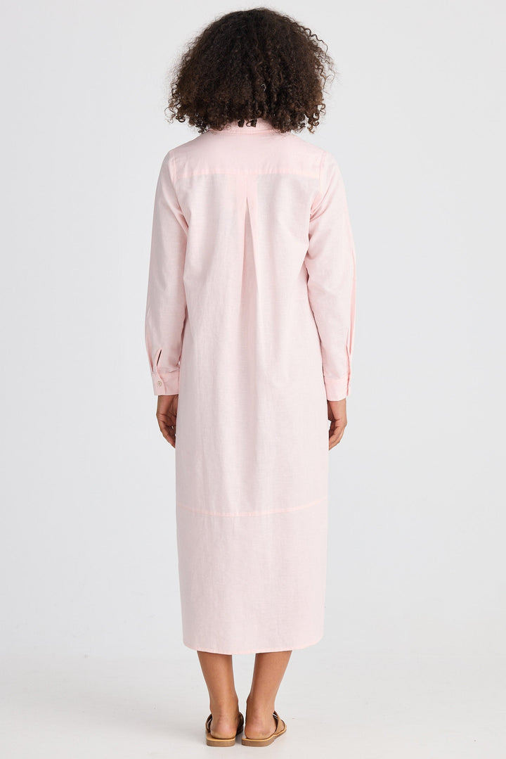 Person wearing a light pink dress with long sleeves on a white background