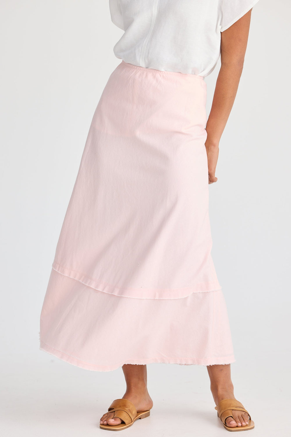 Person wearing a light pink skirt on a white background