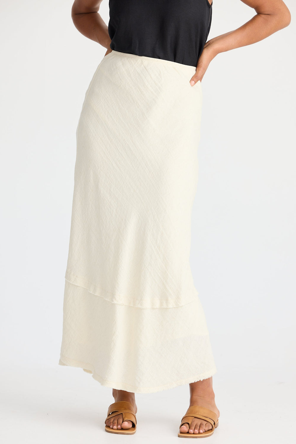 Person wearing a cream skirt on a white background