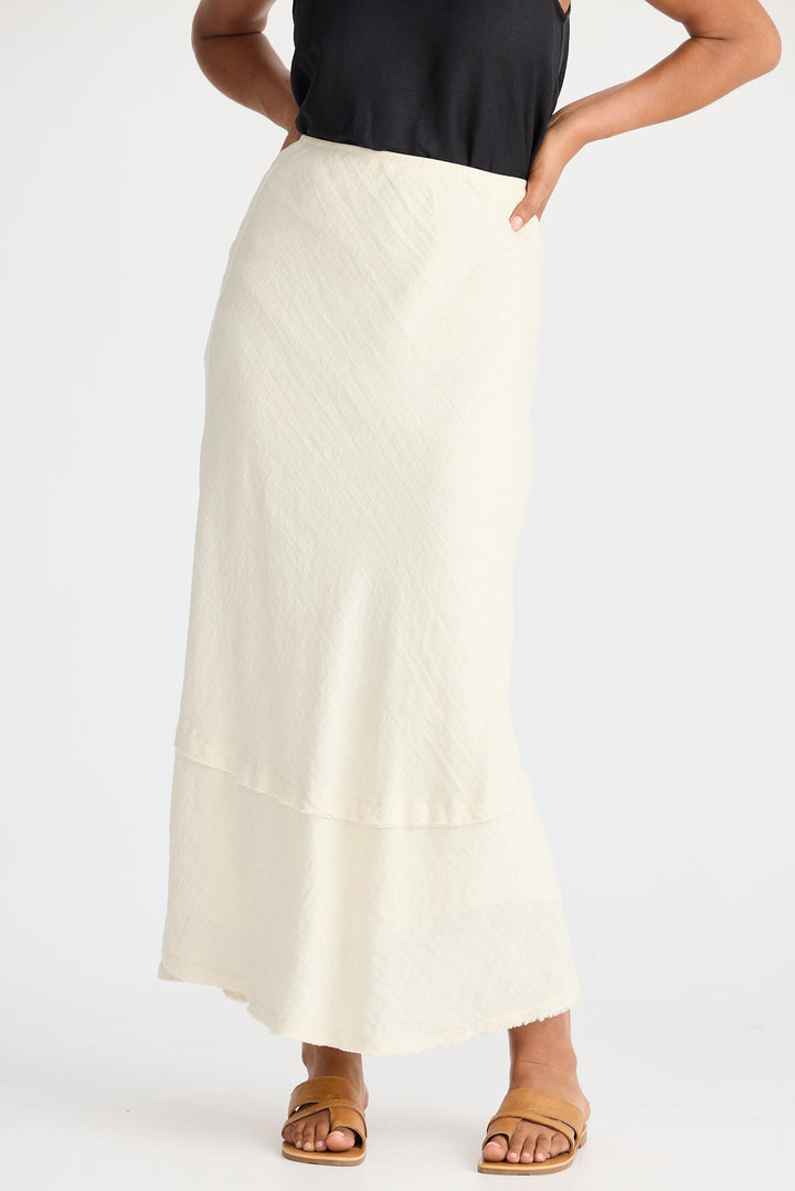 Person wearing a cream skirt on a white background