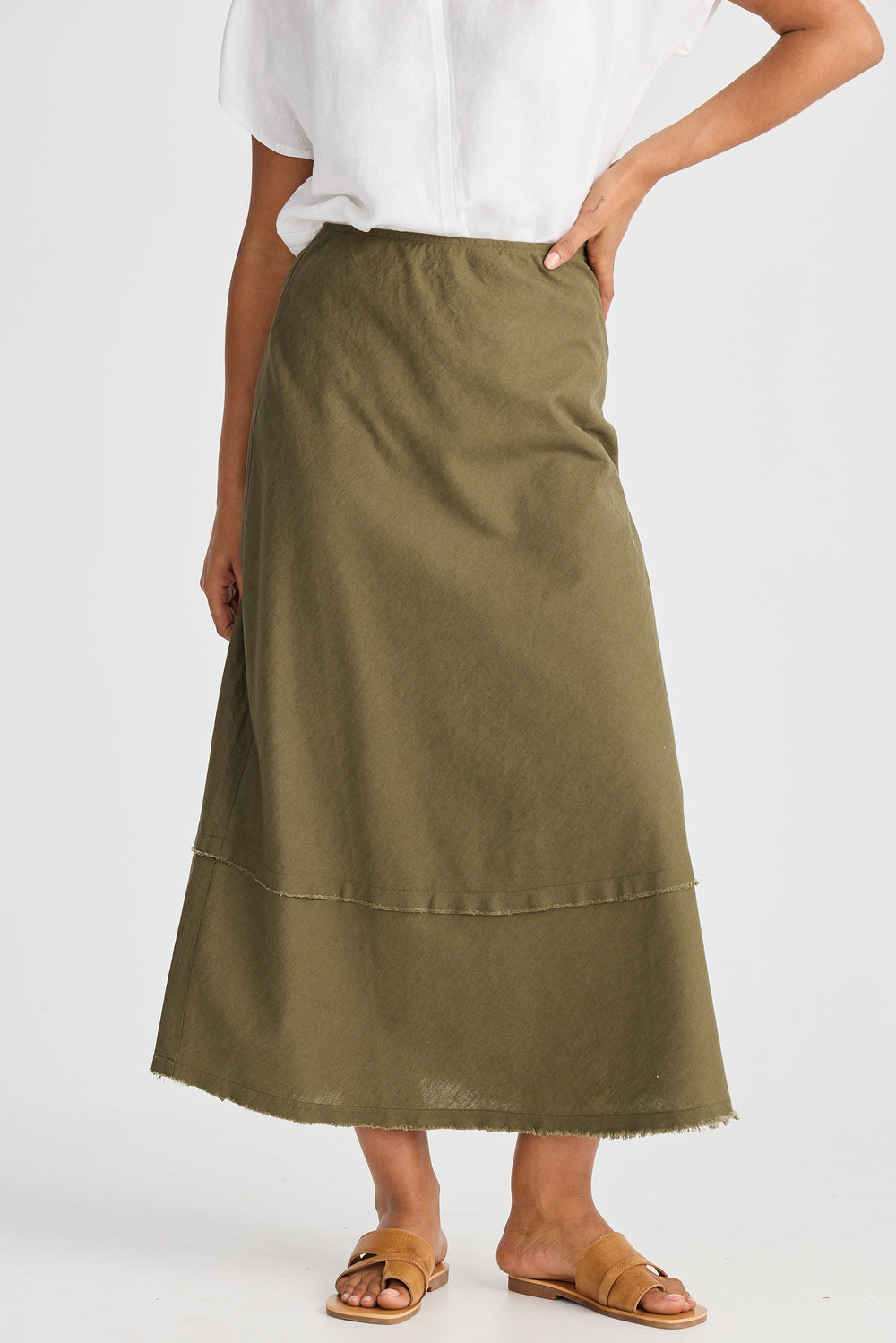 Person wearing a green skirt and white top on a white background
