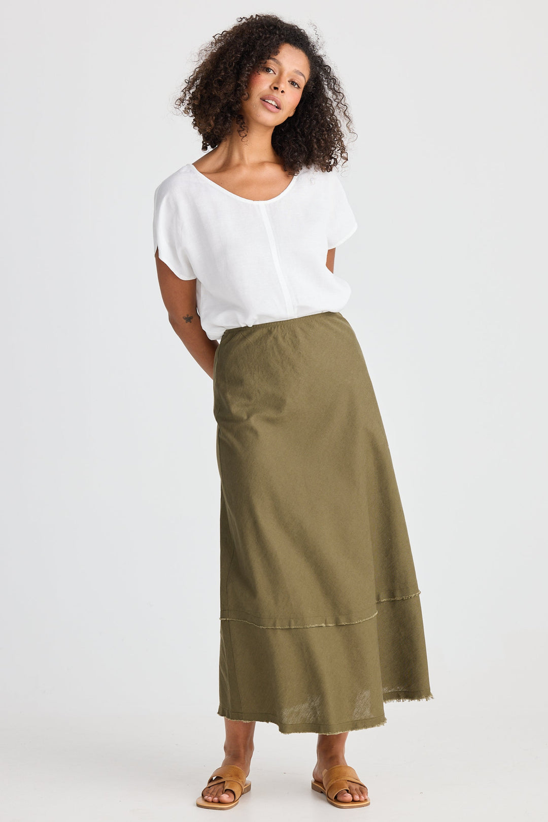 Woman wearing a white top and green skirt on a white background