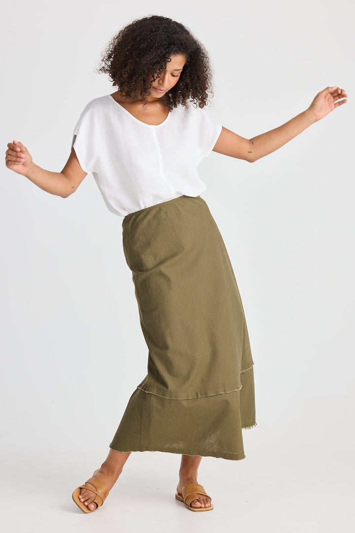 Woman wearing a white top and green skirt on a white background