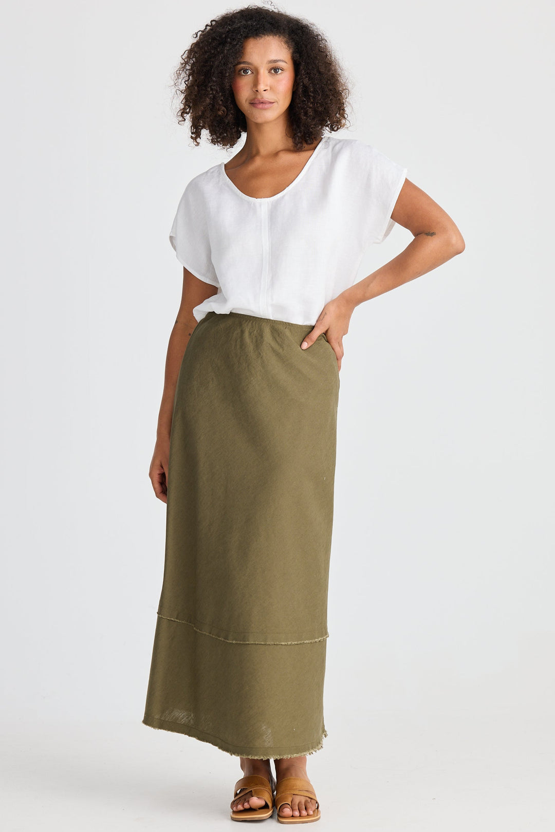 Woman wearing a white top and green skirt on a white background