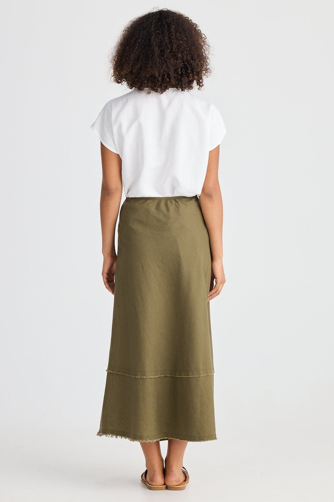 Person wearing a white top and green skirt on a white background