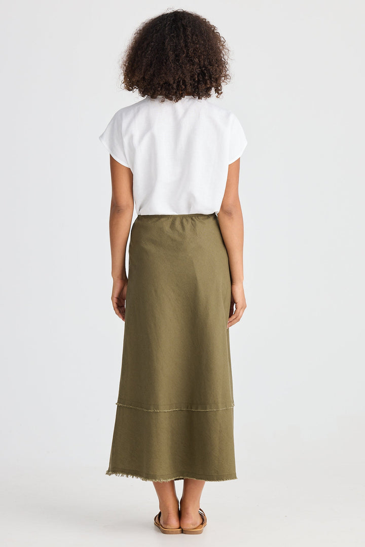 Person wearing a white top and green skirt on a white background
