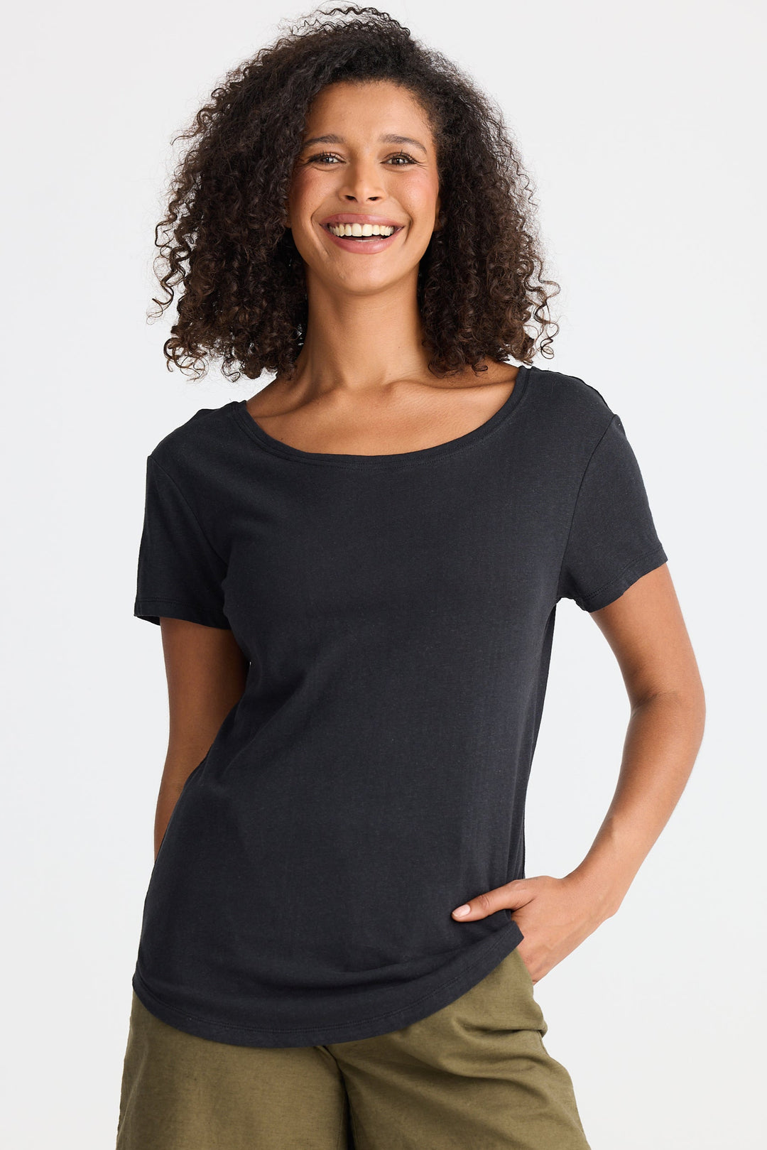 Woman wearing a black t-shirt and green shorts on a white background