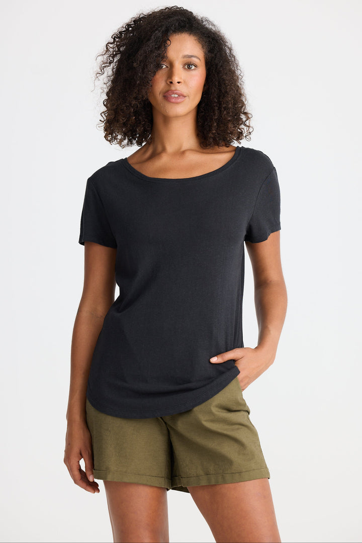 Woman wearing a black t-shirt and green shorts on a white background