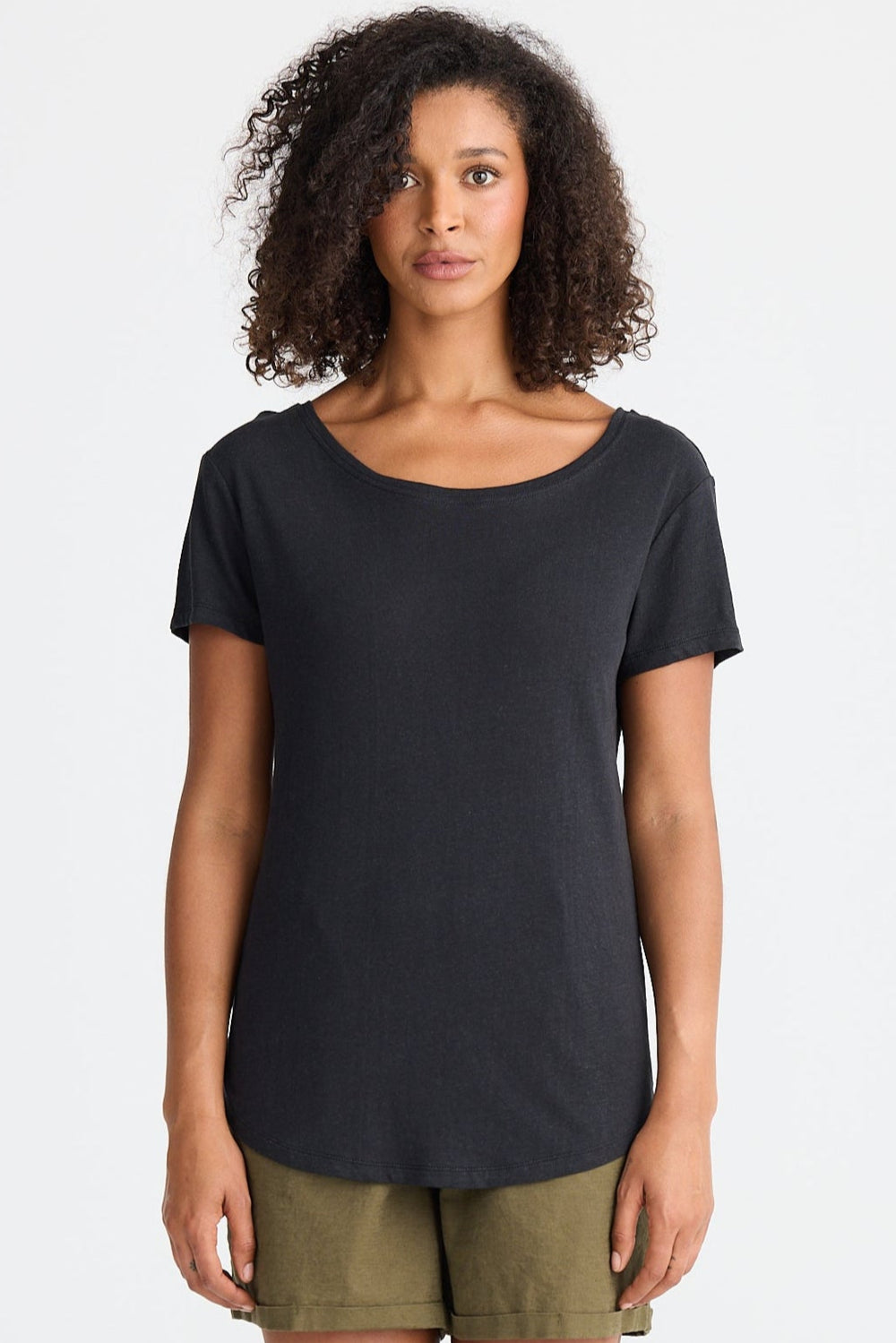 Woman wearing a black t-shirt and green shorts on a white background