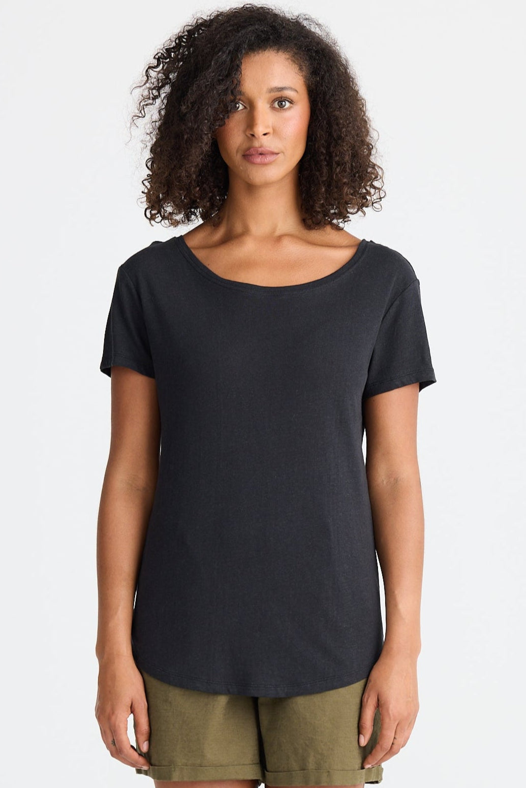 Woman wearing a black t-shirt and green shorts on a white background