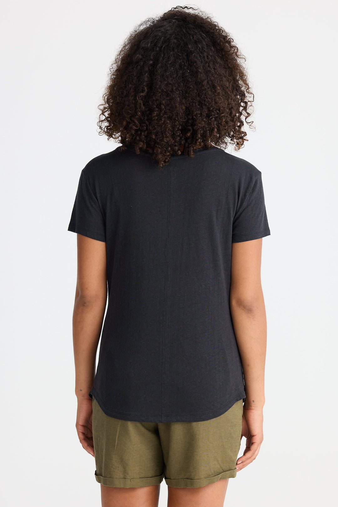 Person wearing a black t-shirt and green shorts on a white background