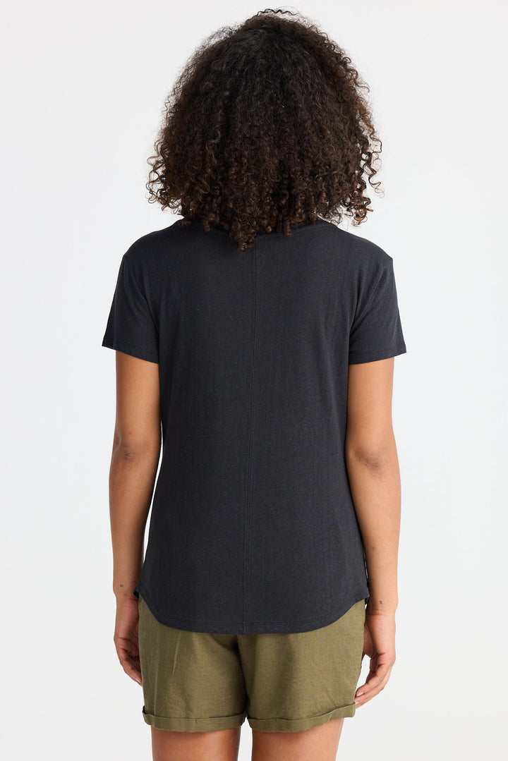 Person wearing a black t-shirt and green shorts on a white background