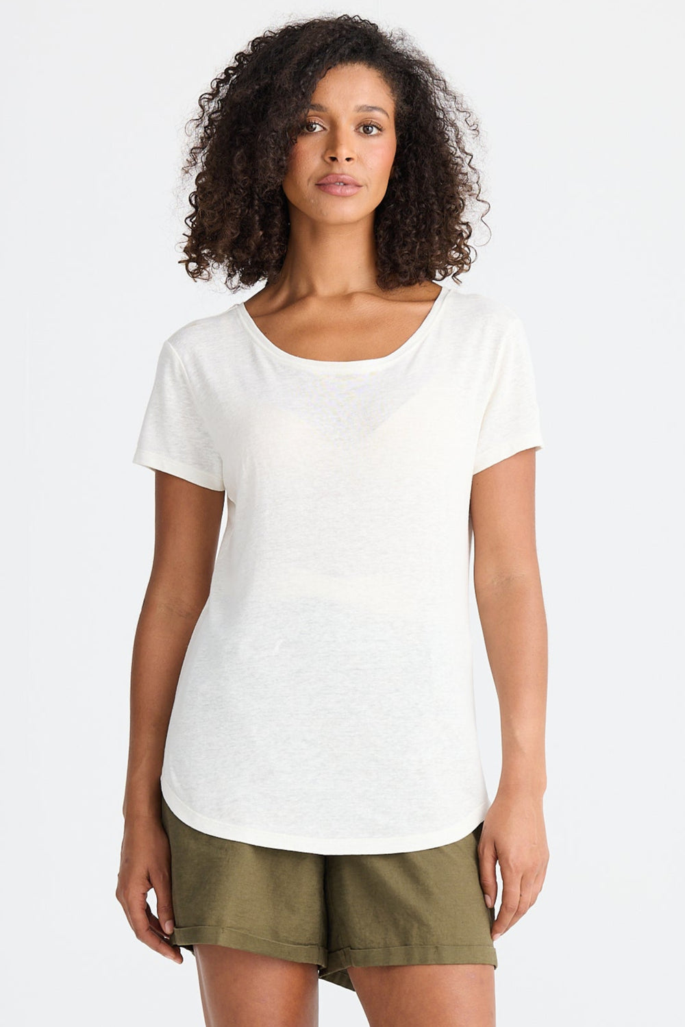 Woman wearing a white top and green shorts on a white background