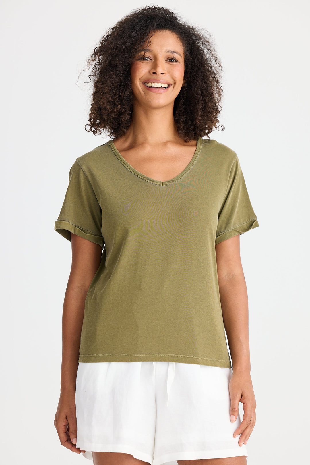 Woman wearing a green t-shirt and white shorts on a white background