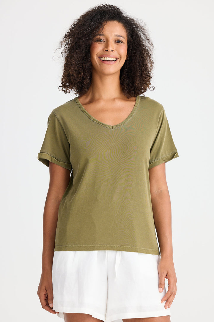 Woman wearing a green t-shirt and white shorts on a white background