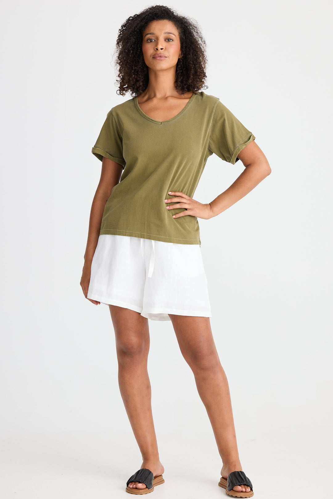 Woman wearing a green t-shirt and white skirt on a white background