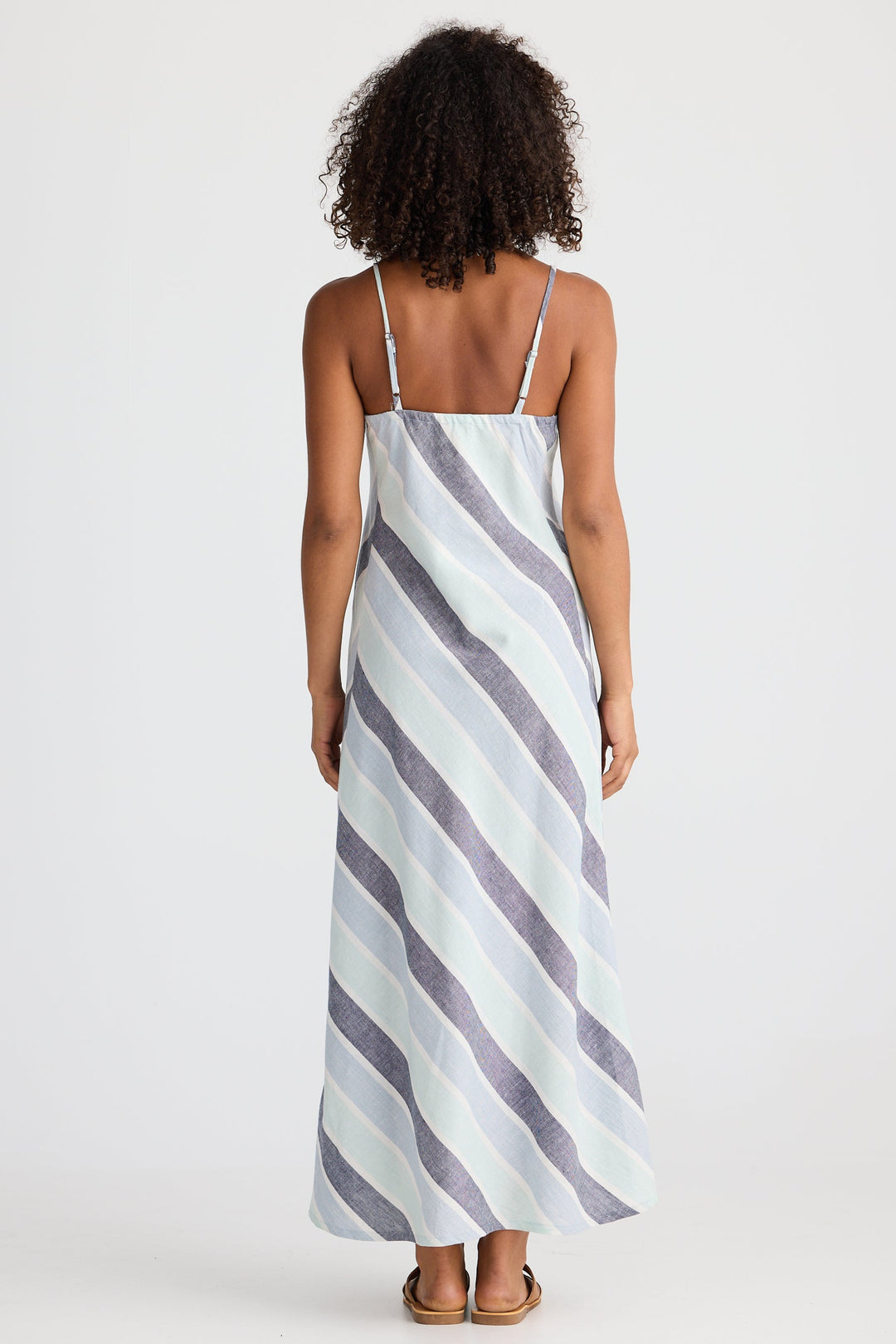 Woman wearing a striped slip dress on a white background