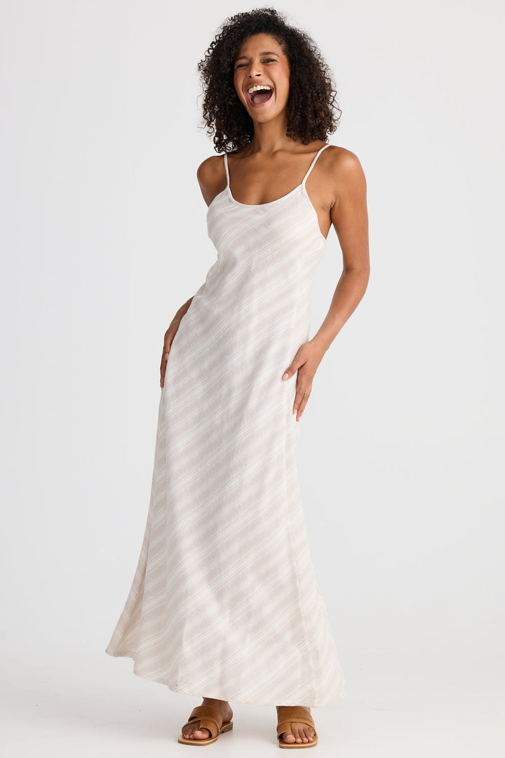 Woman wearing a light striped slip dress on a white background