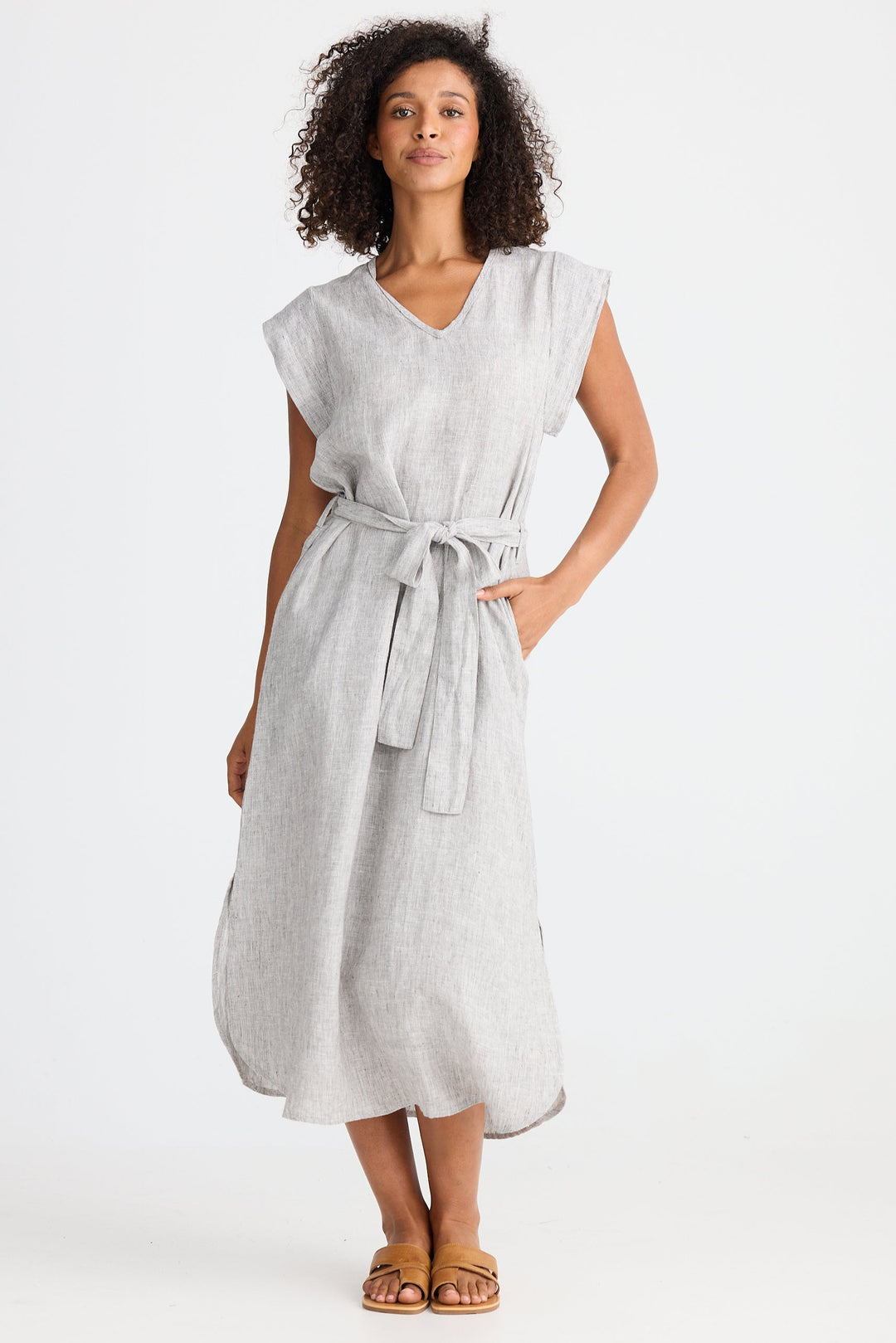 Woman wearing a light gray dress with a belt on a white background