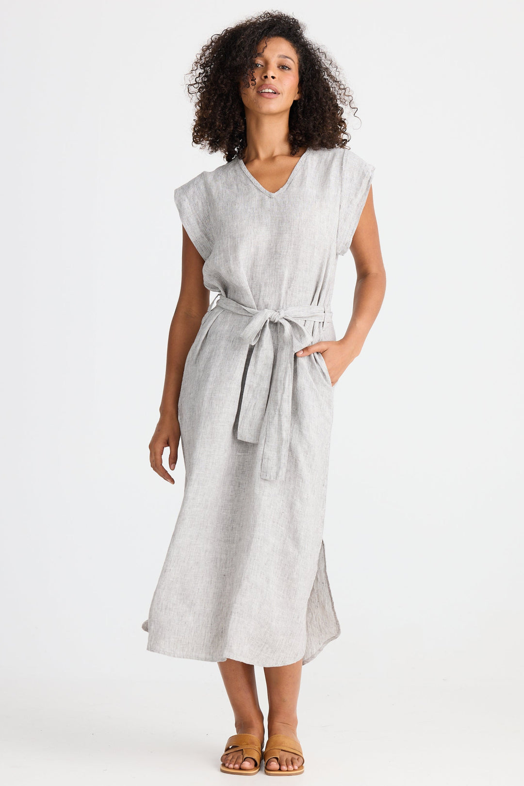 Woman wearing a light gray dress with a belt on a white background