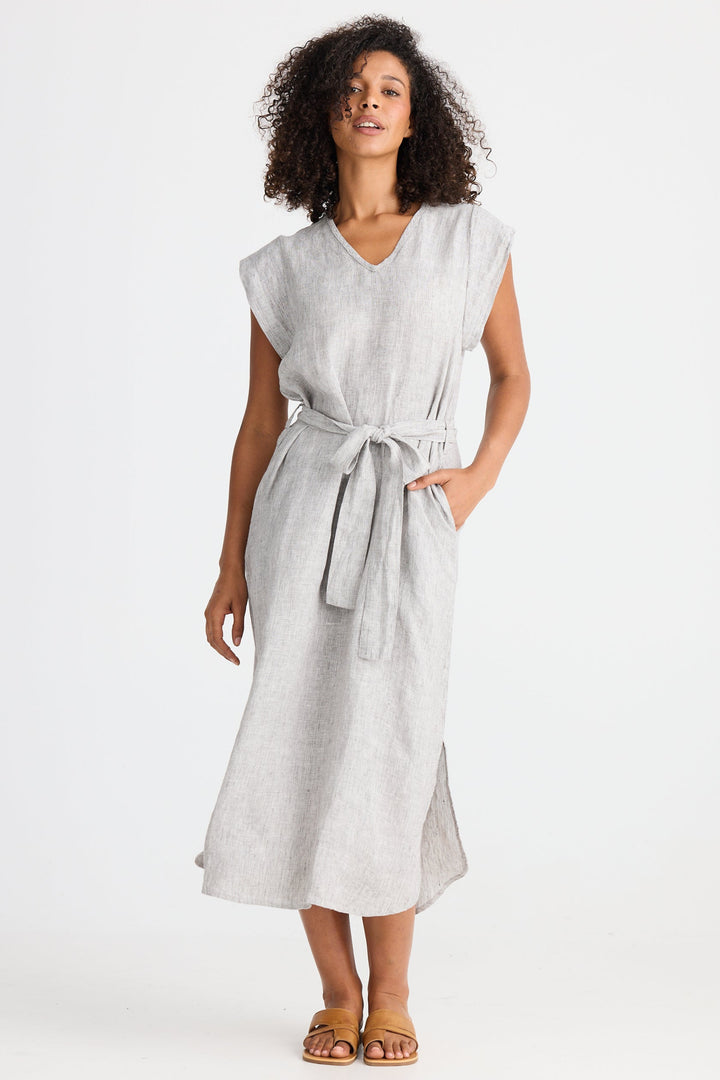 Woman wearing a light gray dress with a belt on a white background