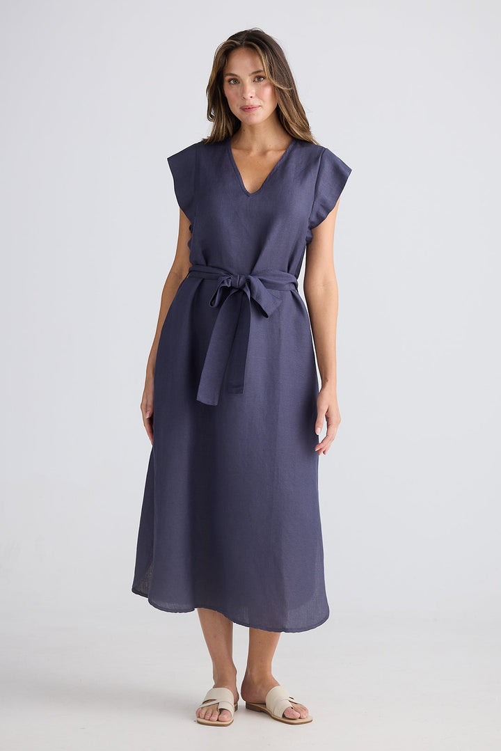 Woman wearing a dark blue dress with a belt on a white background