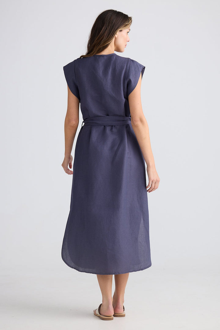 Woman wearing a dark blue dress on a light gray background