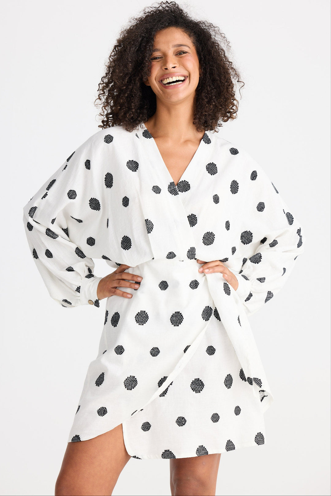 Woman wearing a white dress with black polka dots on a white background
