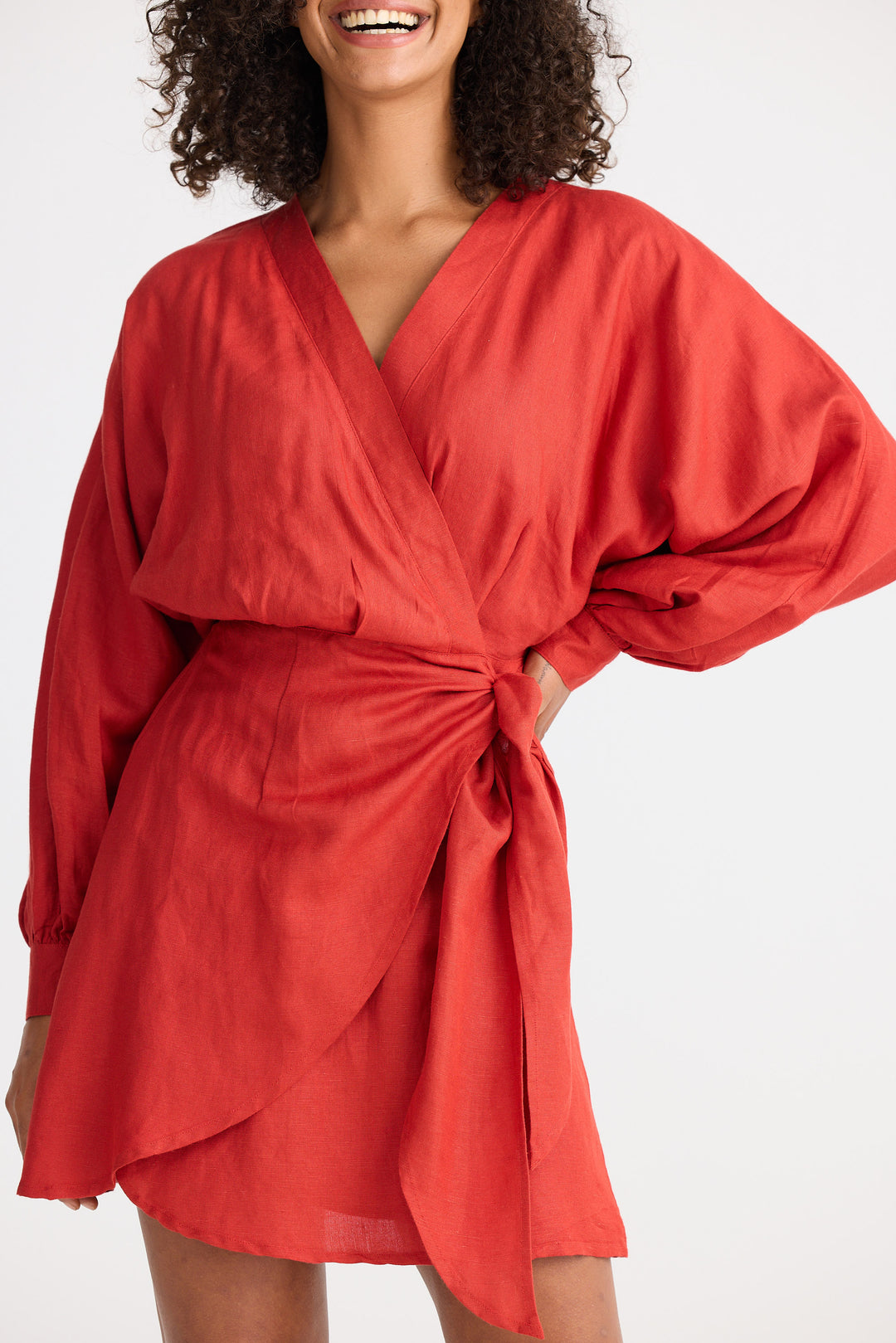 Woman wearing a red wrap dress on a white background