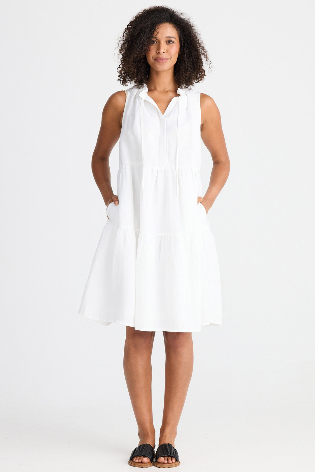 Woman wearing a white sleeveless dress on a white background