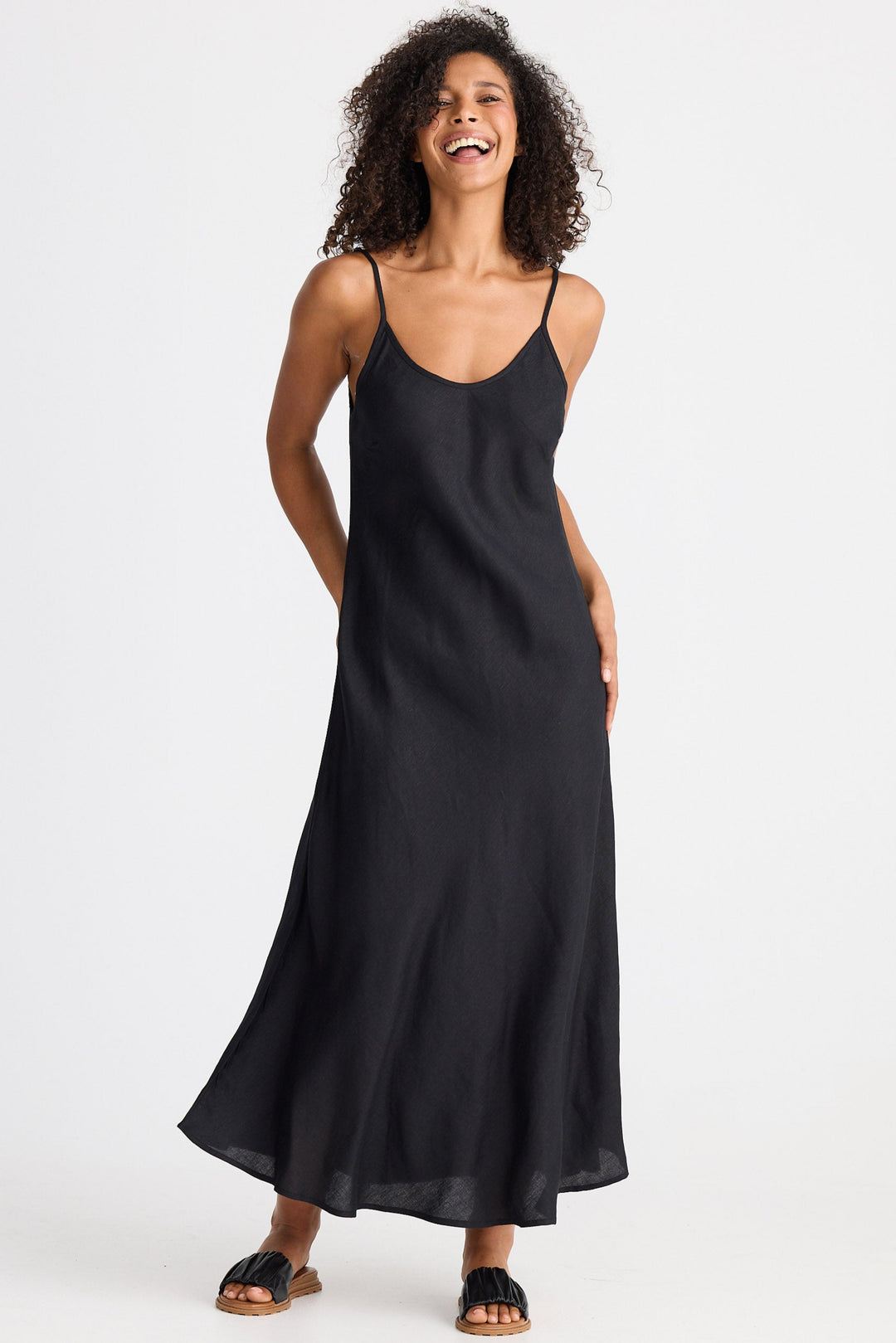 Woman wearing a black slip dress on a white background