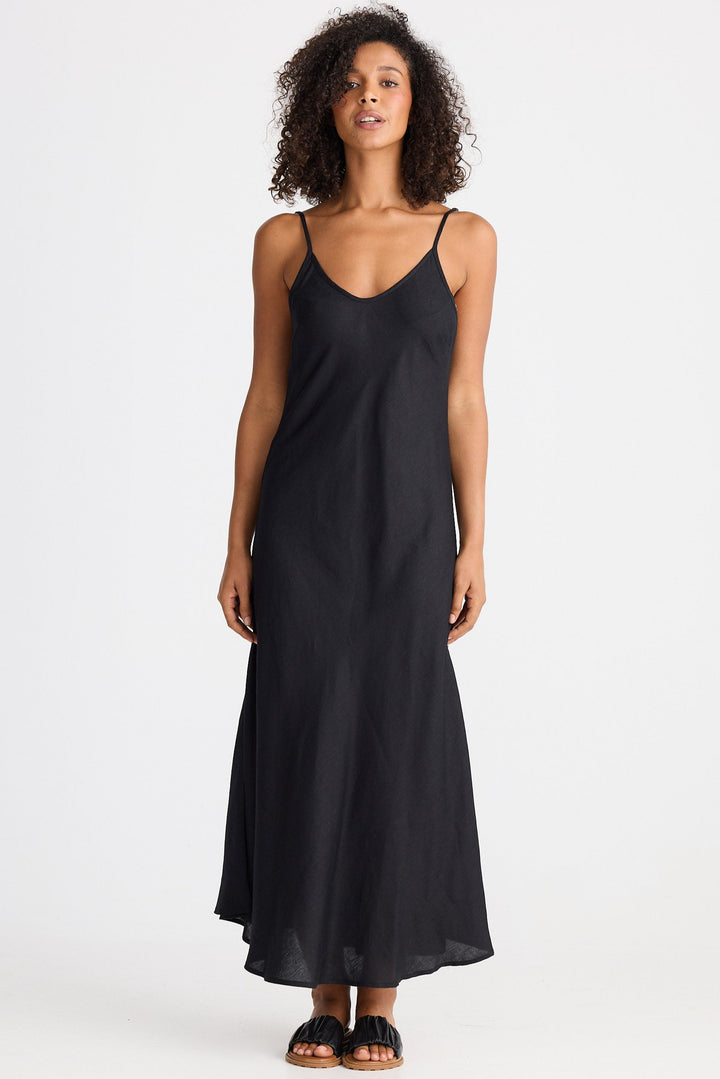Woman wearing a black slip dress on a white background