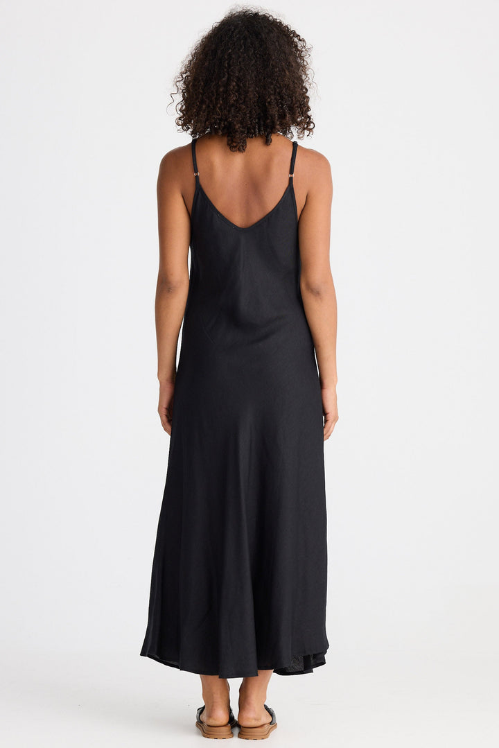 Person wearing a black slip dress on a white background