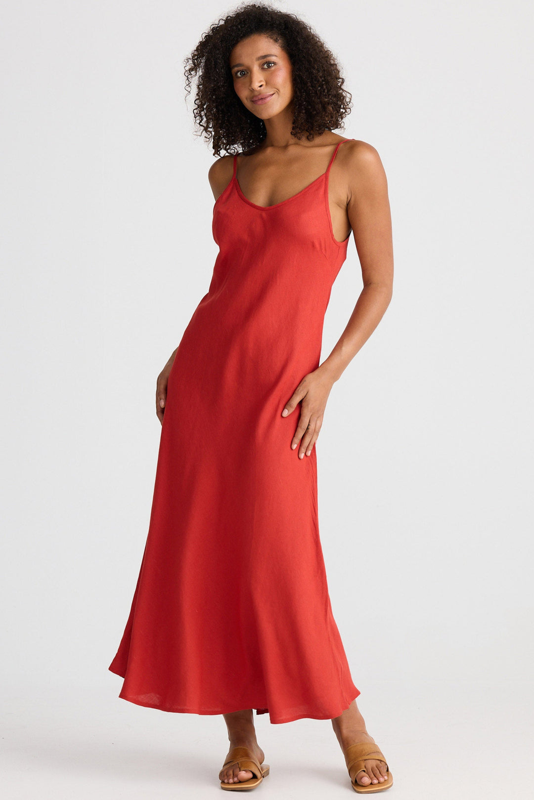 Woman wearing a red slip dress on a white background
