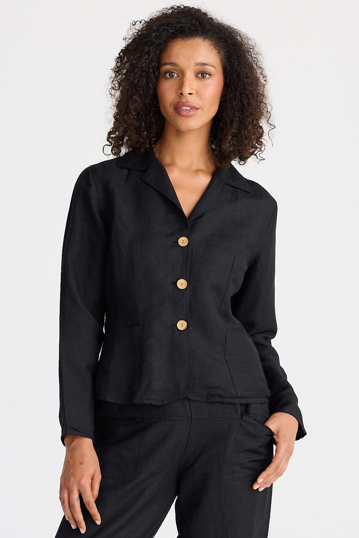 Woman wearing a black jacket with wooden buttons on a white background