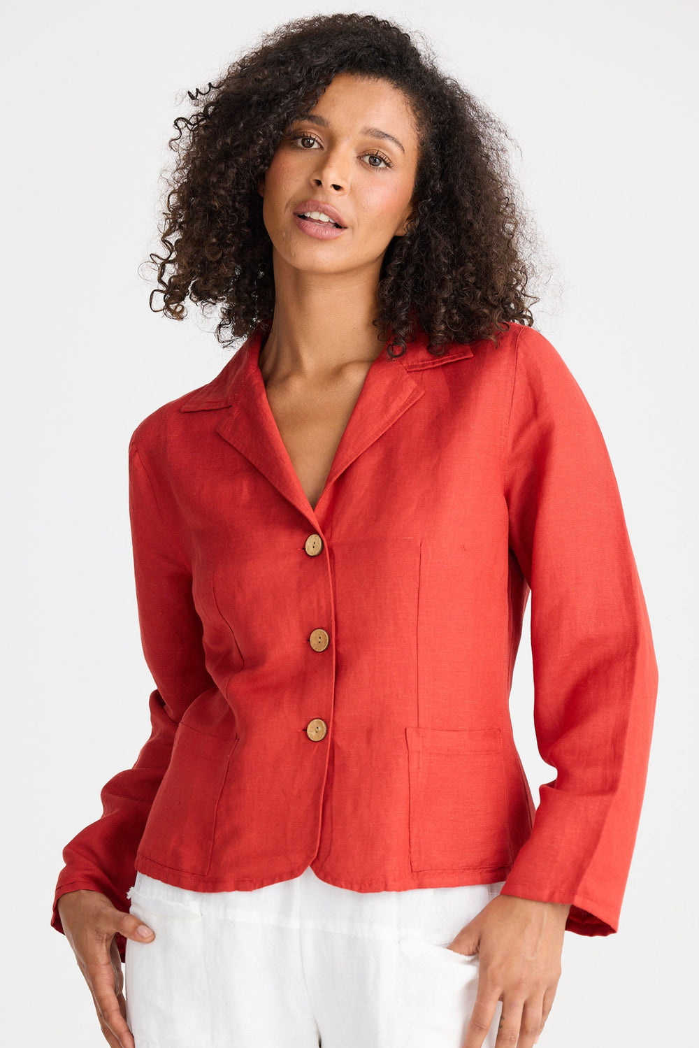 Woman wearing a red jacket with wooden buttons on a white background