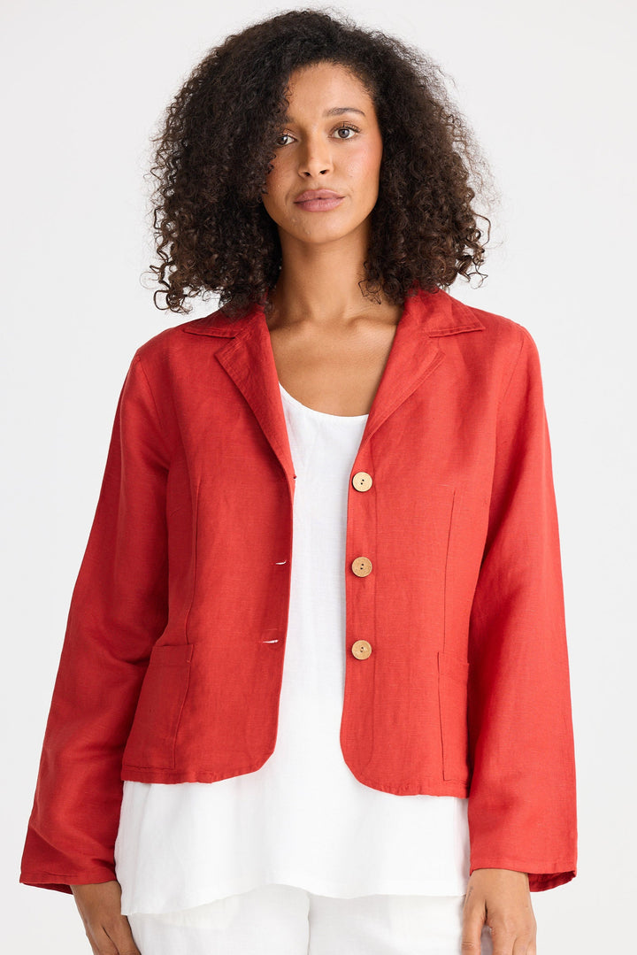 Woman wearing a red jacket over a white top and pants on a white background