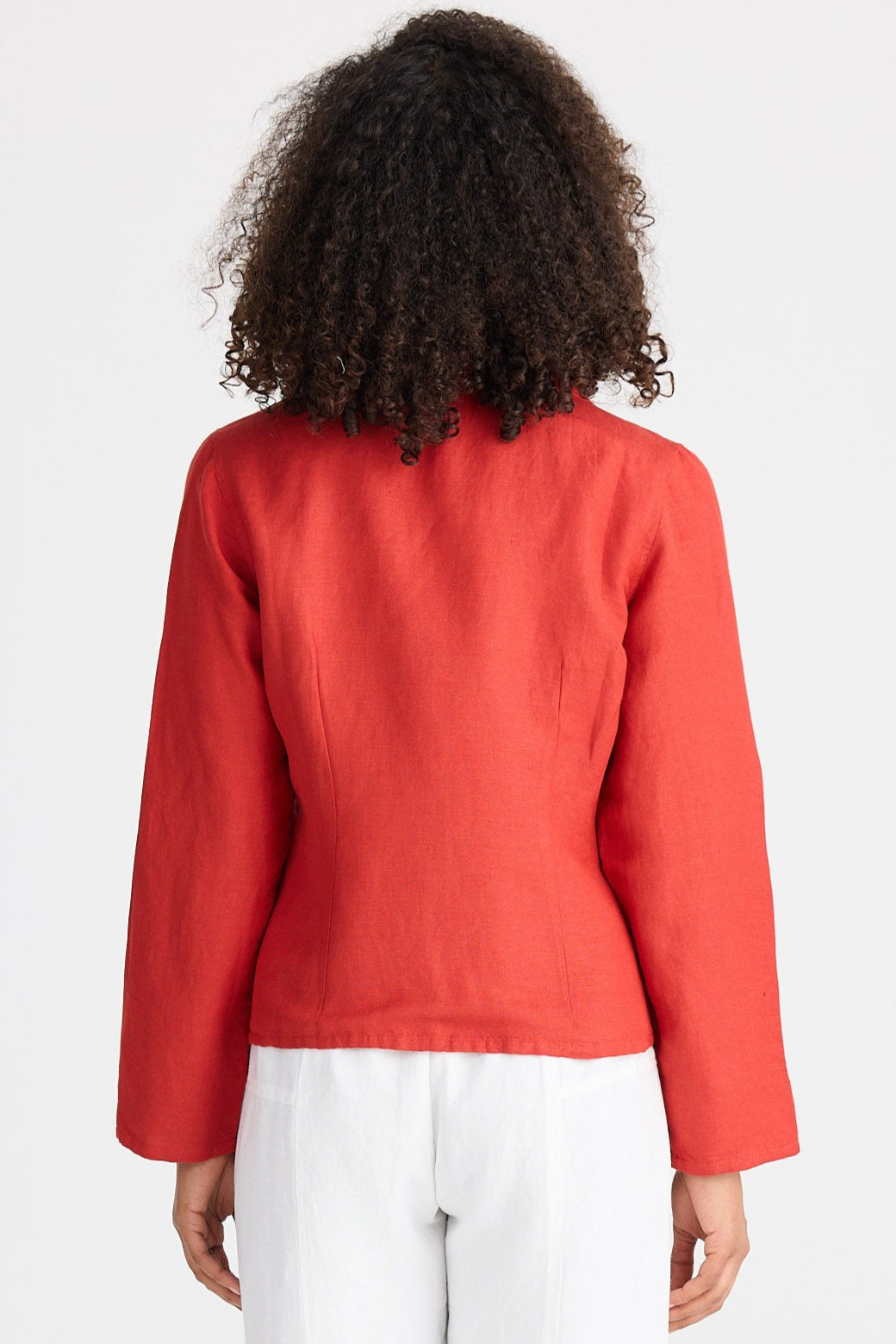 Person wearing a red jacket and white pants on a white background