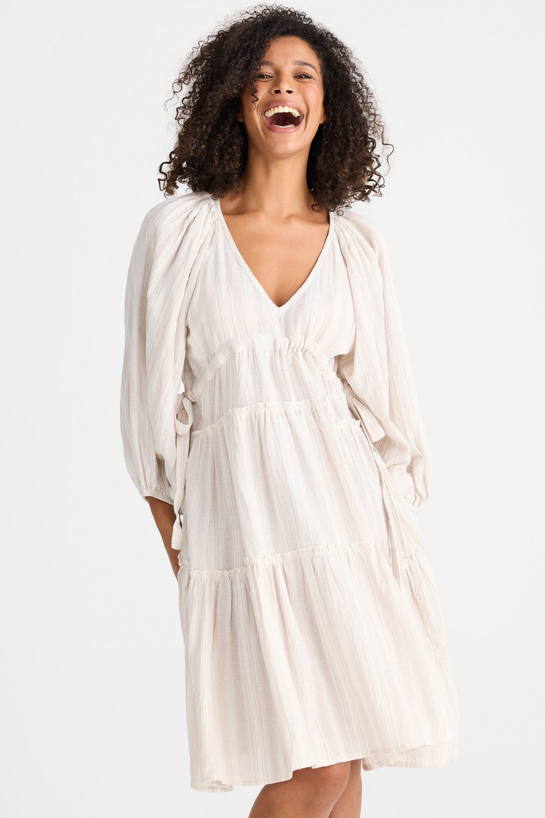 Woman wearing a light dress against a plain background