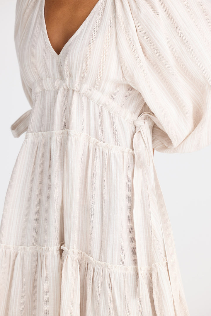 Light dress with long sleeves and tiered skirt on a white background