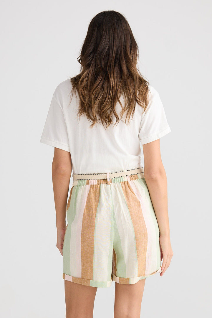 Woman wearing a white t-shirt and striped shorts on a plain background