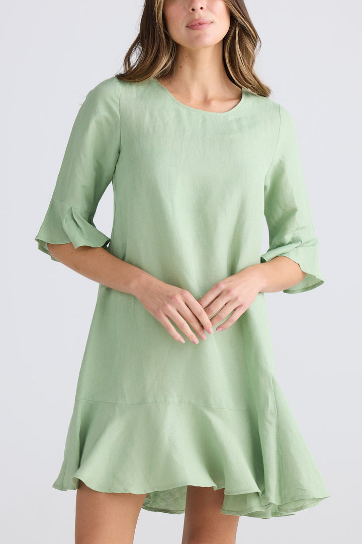 Woman wearing a light green dress against a white background