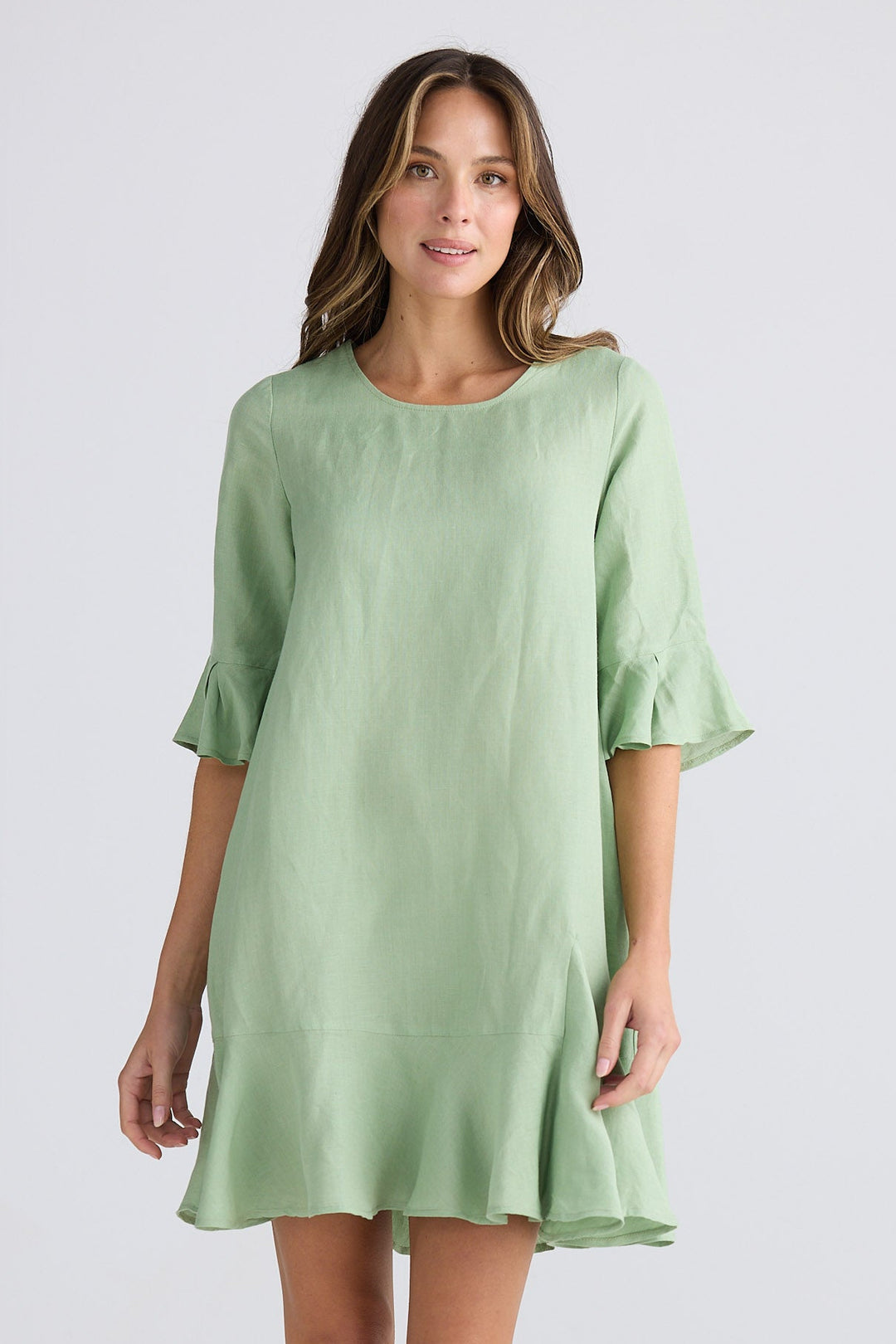 Woman wearing a light green dress on a white background