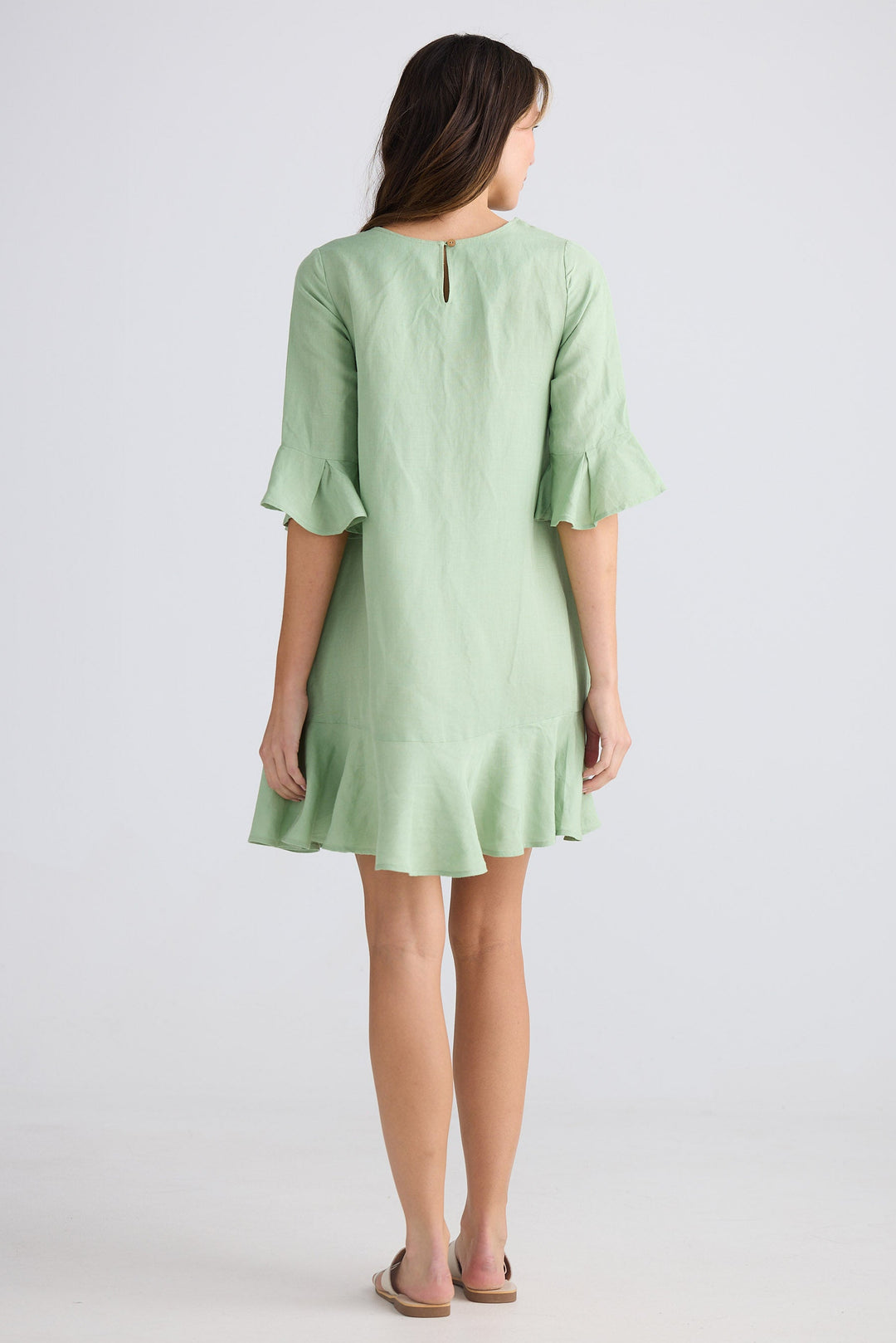 Woman wearing a light green dress on a white background