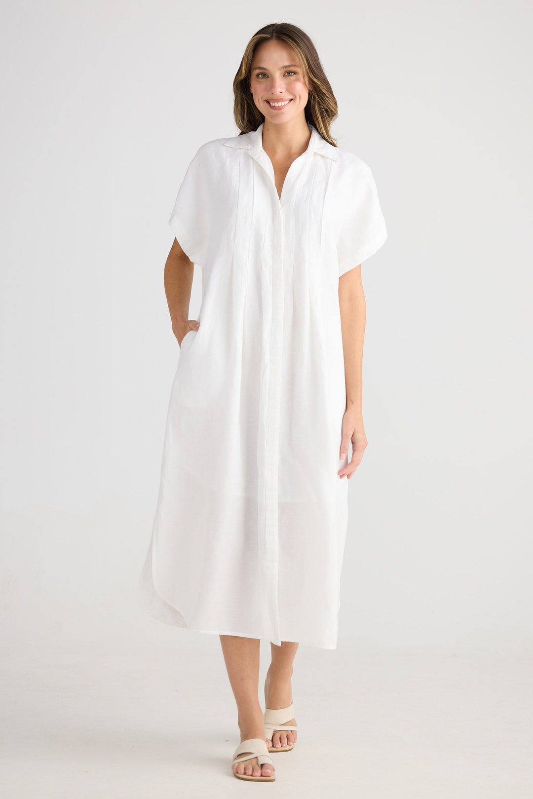 Woman wearing a white dress on a plain background