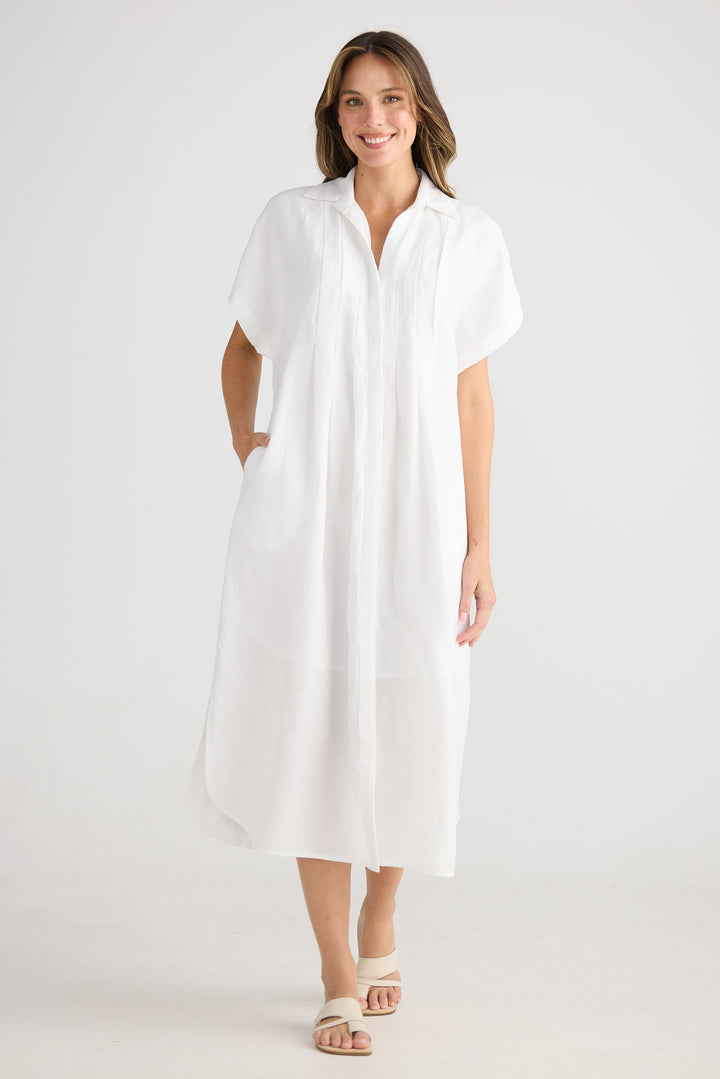 Woman wearing a white dress on a plain background