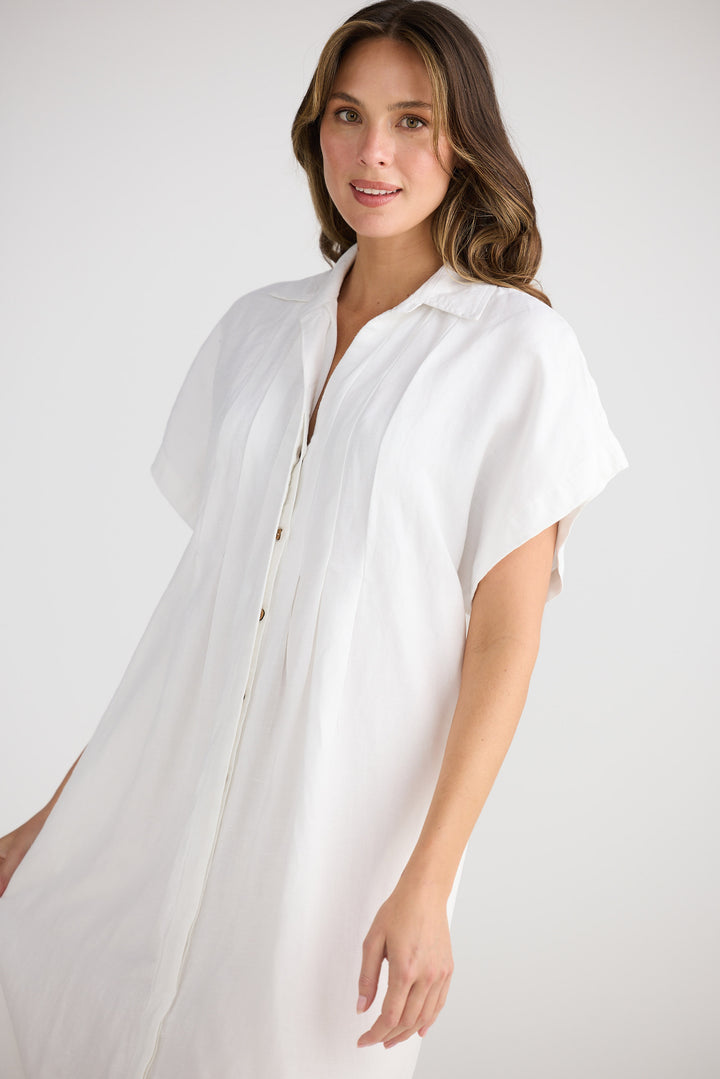 Woman wearing a white dress against a plain background