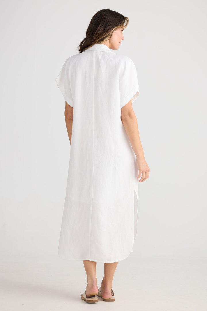 Woman wearing a white dress on a plain background