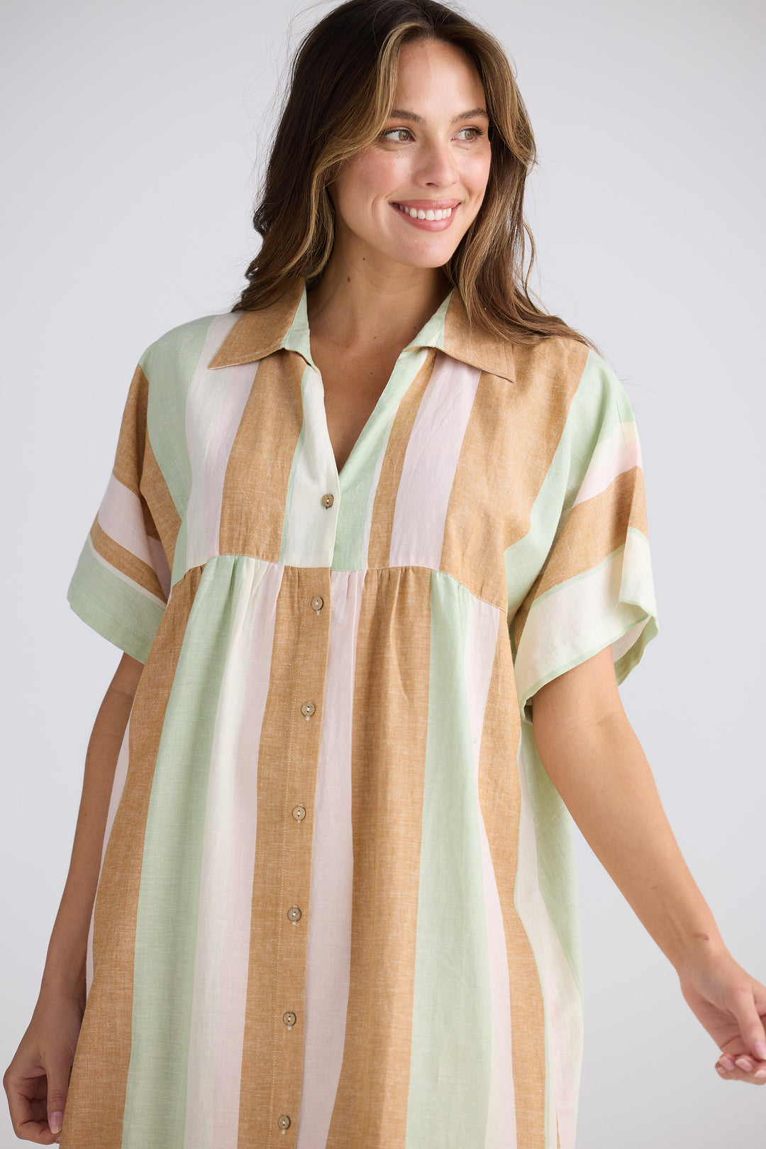 Woman wearing a striped shirt dress with a plain background