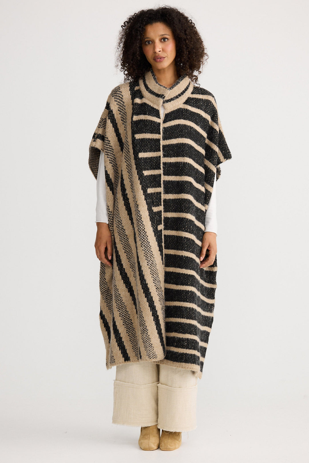 Model wearing black w cedar stripe Mirador Knit Cape, front view on white background